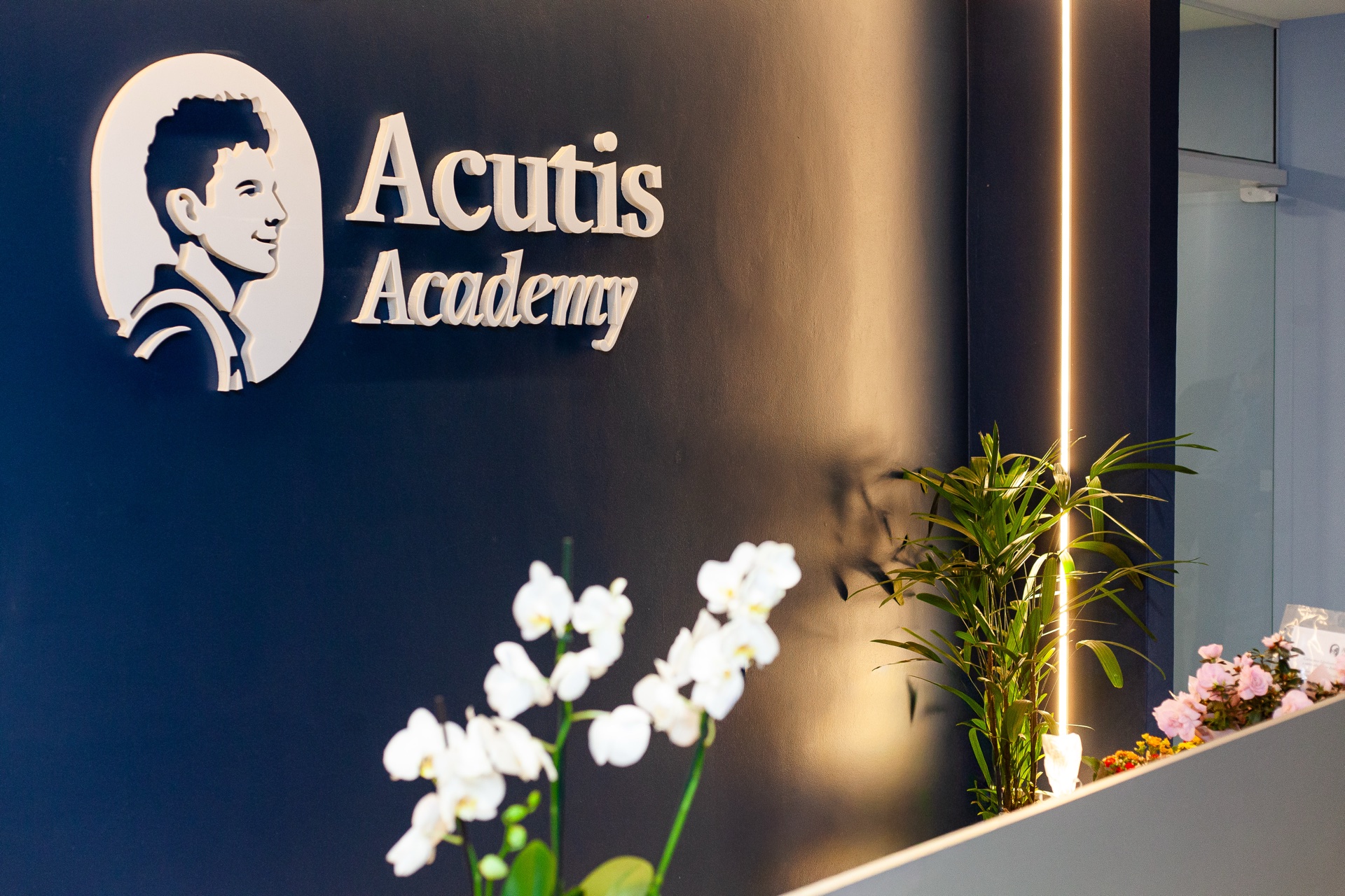 Acutis Academy headquarters — brand logo applied to the reception wall
